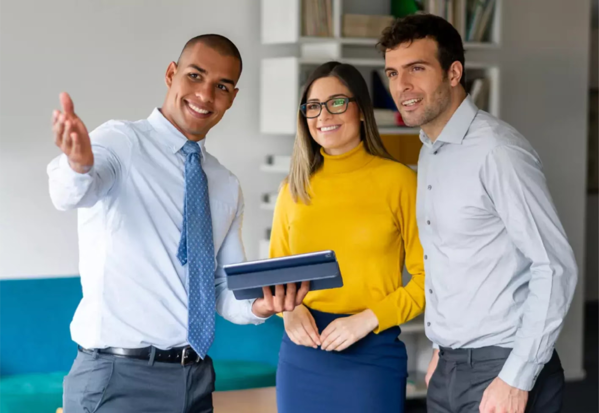 Three real estate professionals meeting with a client.